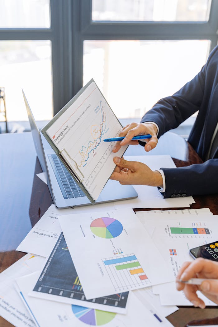 hero-homepage Business professionals discussing financial graphs and charts in an office setting.